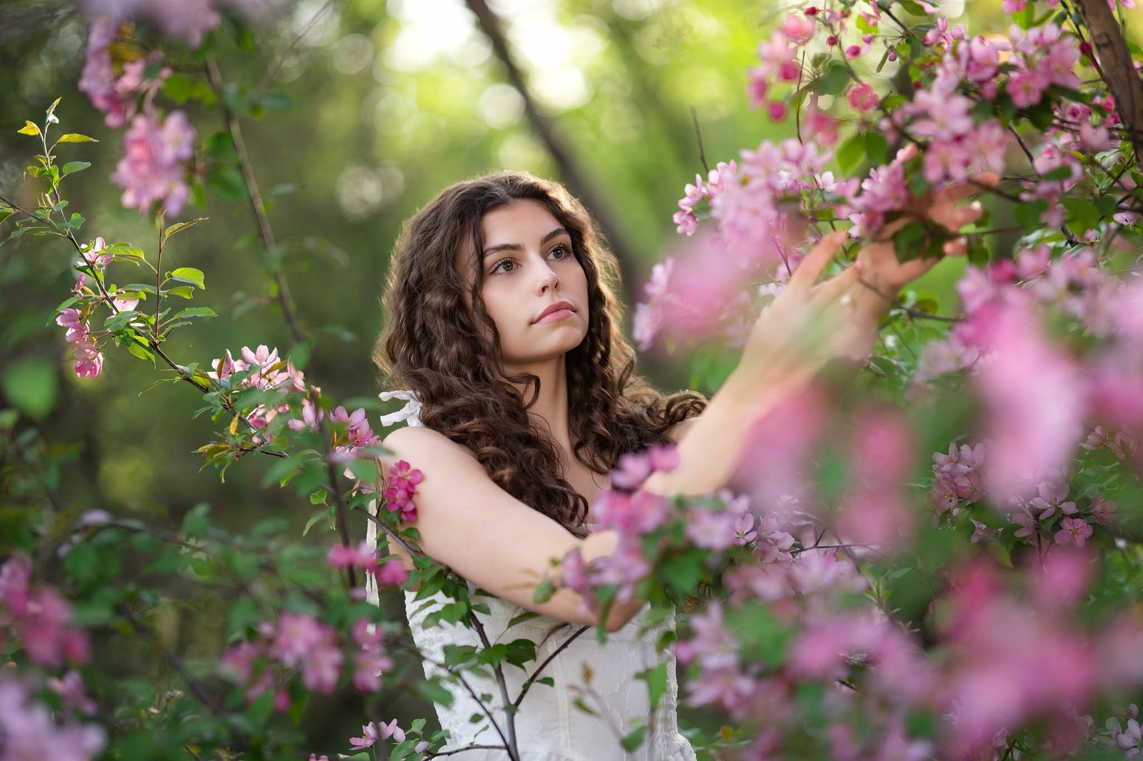 Portrait among pink spring blossoms